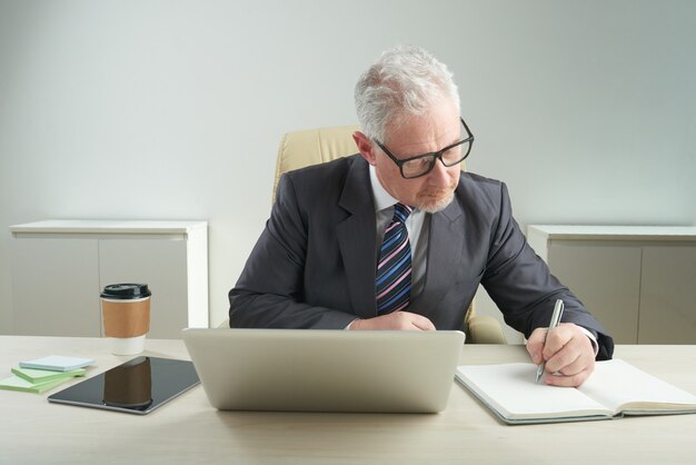 Anciano empresario centrado en el trabajo