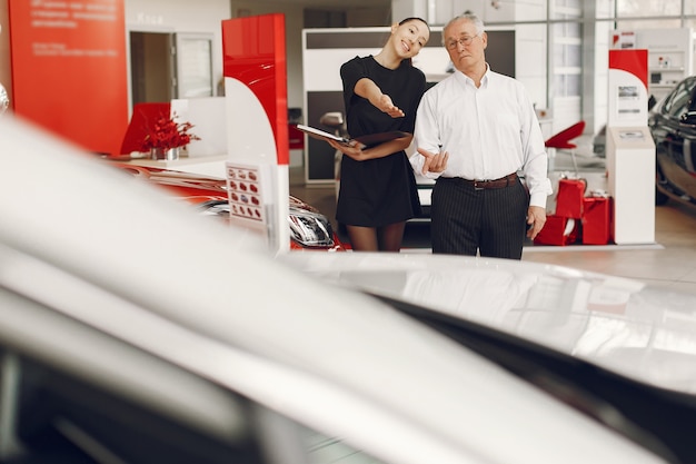 Anciano con estilo y elegante en un salón del automóvil