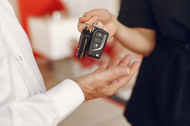 Anciano con estilo y elegante en un salón del automóvil