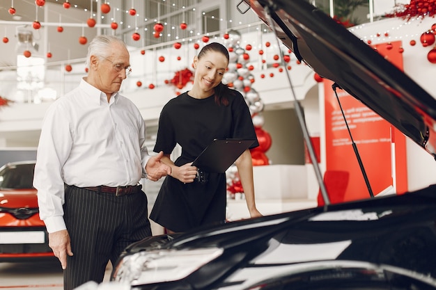 Anciano con estilo y elegante en un salón del automóvil