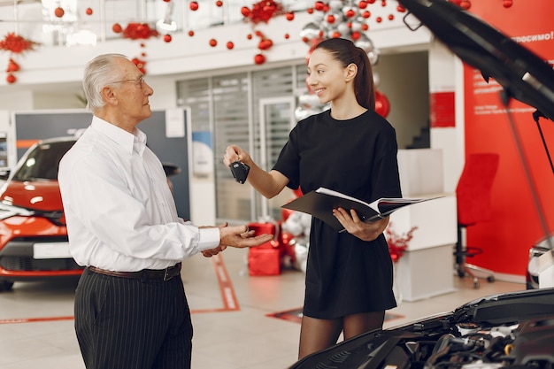 Anciano con estilo y elegante en un salón del automóvil