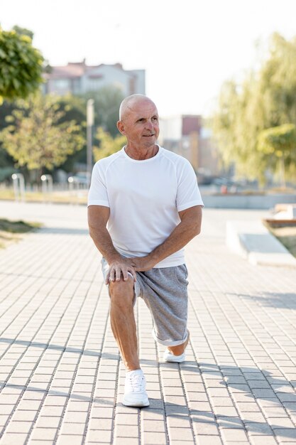 Anciano estirando al aire libre