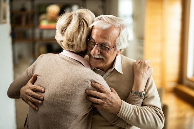 Foto gratuita un anciano feliz abrazando a su esposa mientras baila con ella en casa