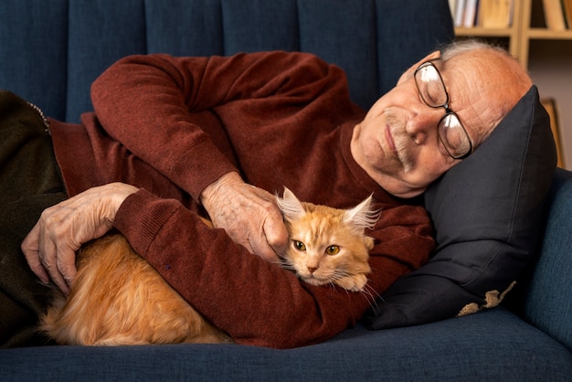 Foto gratuita anciano con gato mascota
