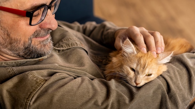 Foto gratuita anciano con gato mascota