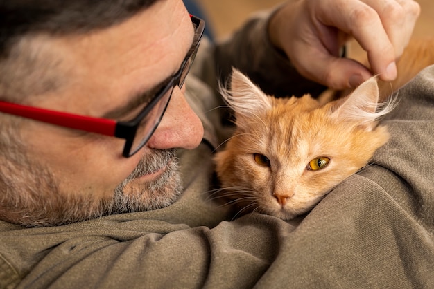 Foto gratuita anciano con gato mascota