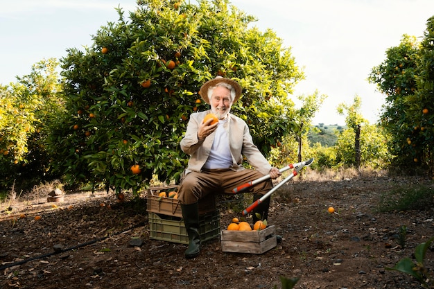 Foto gratuita anciano con naranjas frescas