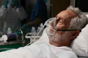 Foto gratuita anciano con respirador en una cama de hospital