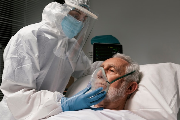 Foto gratuita anciano con respirador en una cama de hospital