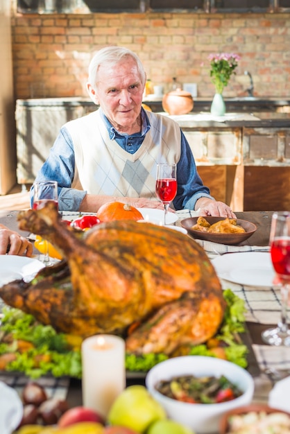 Foto gratuita anciano sentado a la mesa con comida