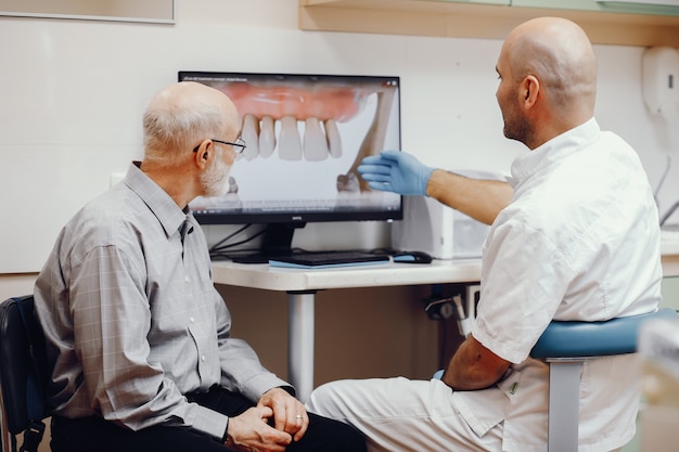 Anciano sentado en la oficina del dentista