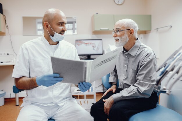 Anciano sentado en la oficina del dentista