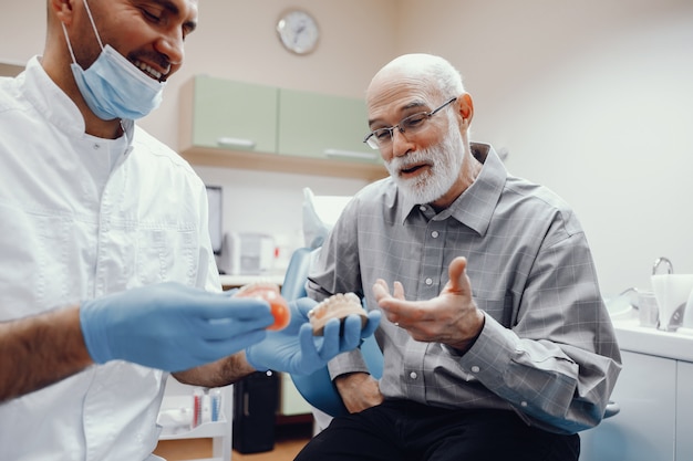 Anciano sentado en la oficina del dentista