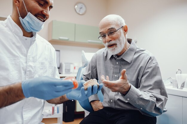 Anciano sentado en la oficina del dentista