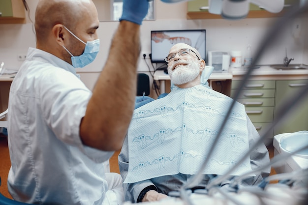 Anciano sentado en la oficina del dentista