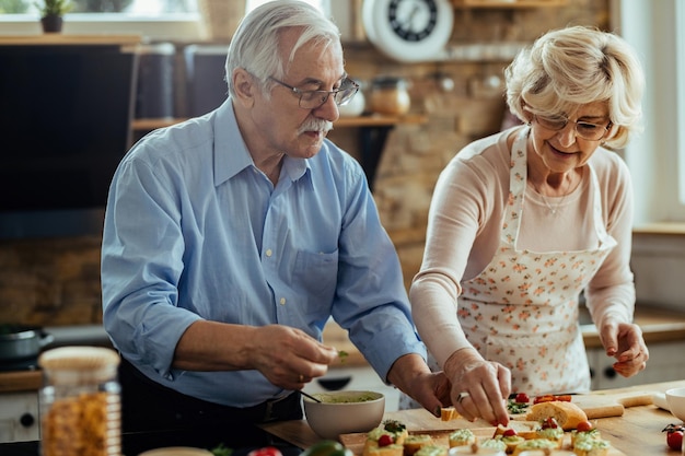 El anciano y su esposa disfrutan preparando comida en su cocina