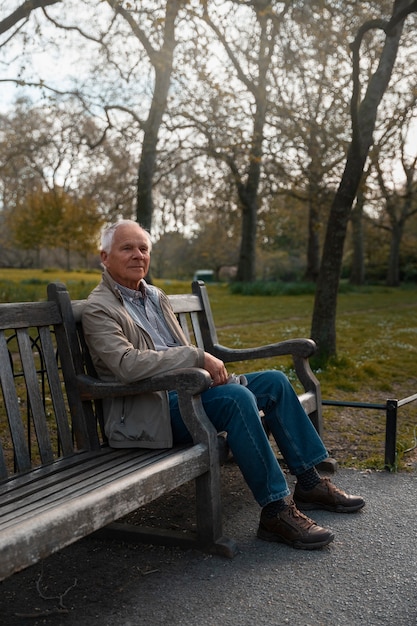 Anciano de tiro completo sentado en un banco