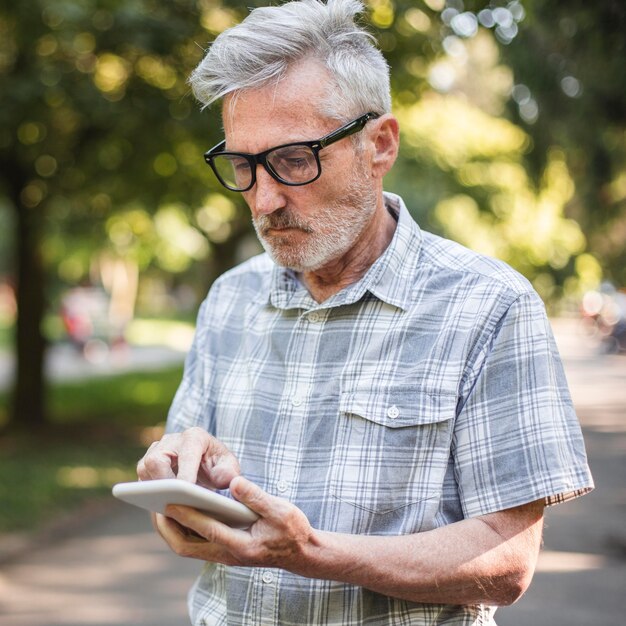Anciano de tiro medio con smartphone