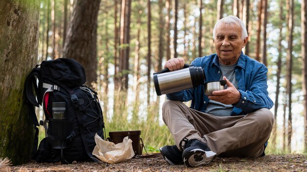 Anciano viajando al aire libre con mochila