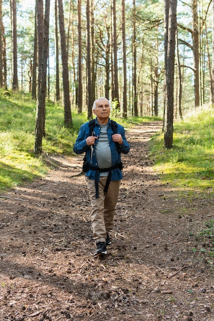 Anciano viajando con mochila en la naturaleza