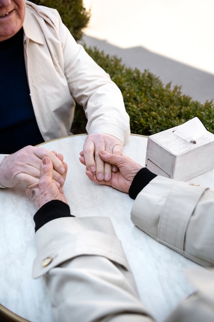 Ancianos de alto ángulo tomados de la mano