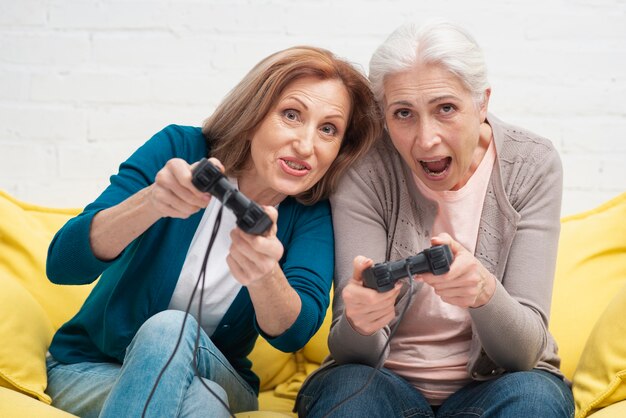 Ancianos amigos jugando con controladores