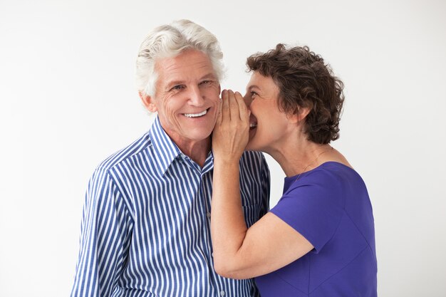 Ancianos susurrantes de la mujer sonriente secreto para marido