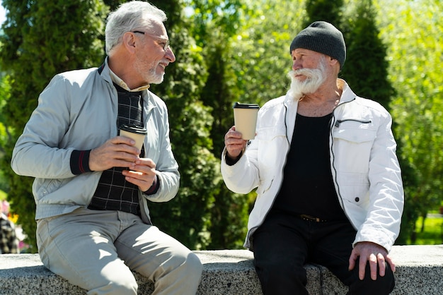 Ancianos de tiro medio con tazas de café