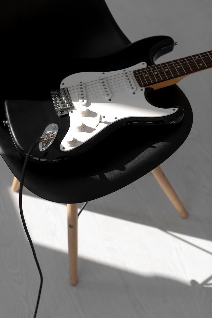 Foto gratuito ángulo alto de guitarra eléctrica en silla