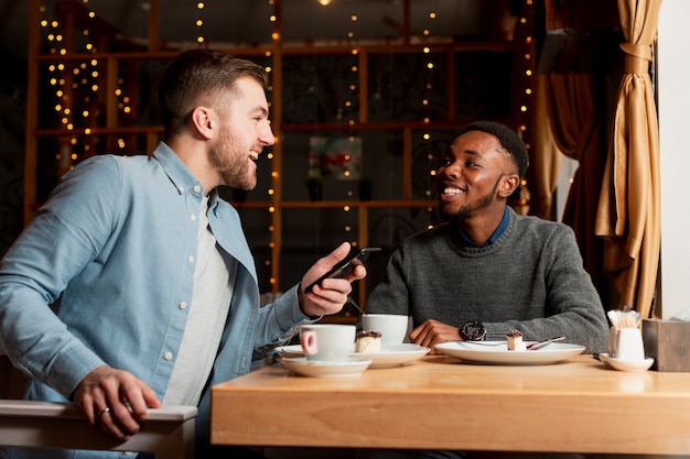 Bajo ángulo amigos varones en el restaurante