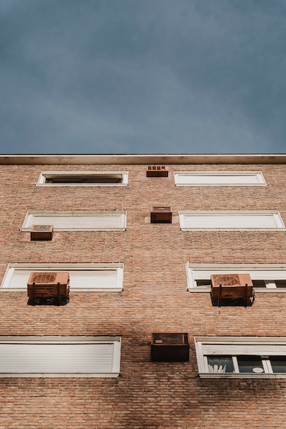 Ángulo bajo de edificio residencial en la ciudad con unidades de aire acondicionado