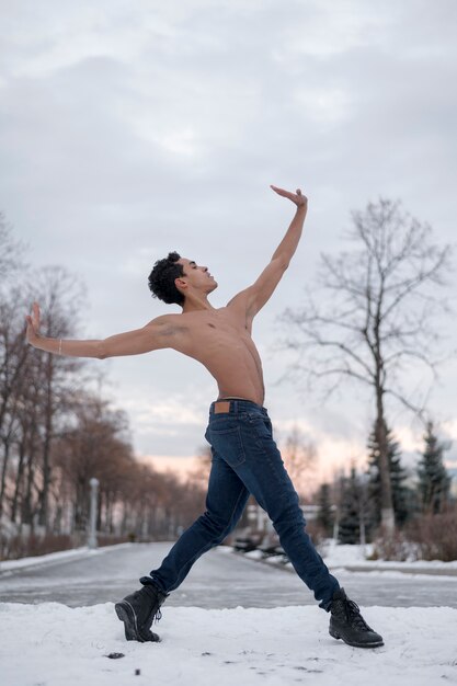 Bajo ángulo masculino bailando ballet al aire libre