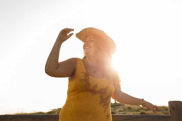 Foto gratuita Ángulo bajo de mujer al aire libre con sombrero