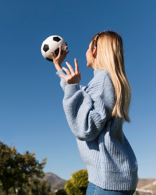 Foto gratuita Ángulo bajo de niña atrapando el balón de fútbol