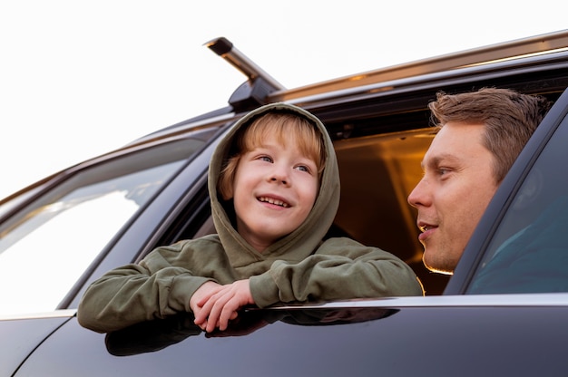 Foto gratuita Ángulo bajo de padre e hijo en el coche en un viaje por carretera