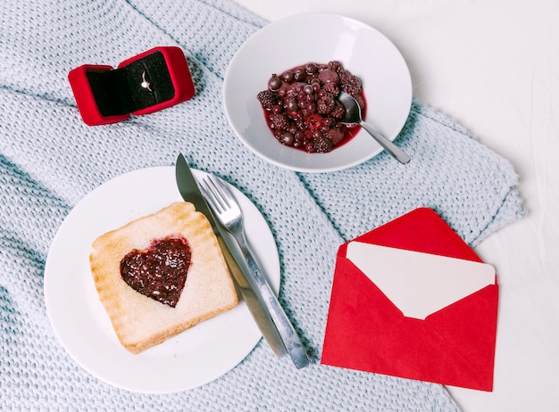 Foto gratuita anillo de boda con pan tostado con mermelada en forma de corazón en la bufanda