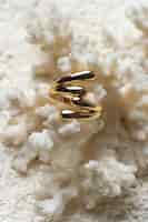 Foto gratuita anillo de oro caro que se muestra sobre fondo de coral blanco