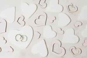 Foto gratuita anillos de boda de diamante en forma de corazón blanco y rosa sobre el fondo de hormigón