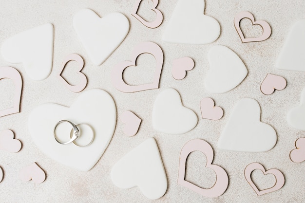 Anillos de boda de diamante en forma de corazón blanco y rosa sobre el fondo de hormigón