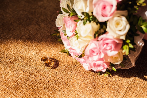 anillos de boda con ramo de rosas rosadas