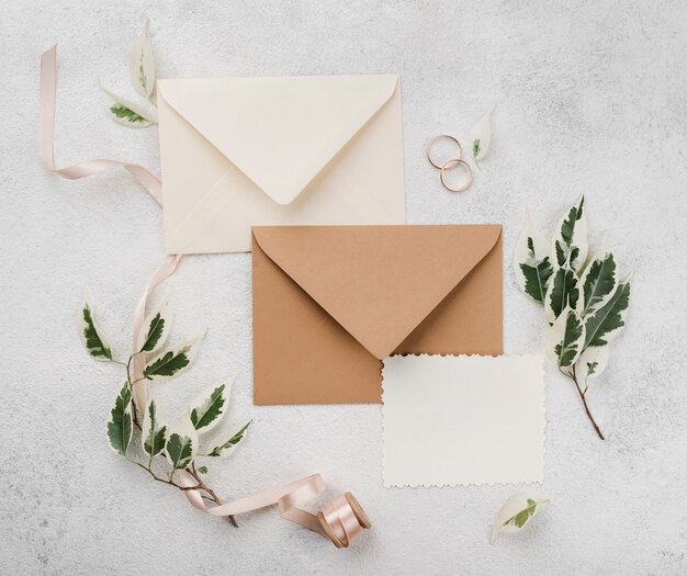 Anillos de boda y tarjetas de invitación con flores.