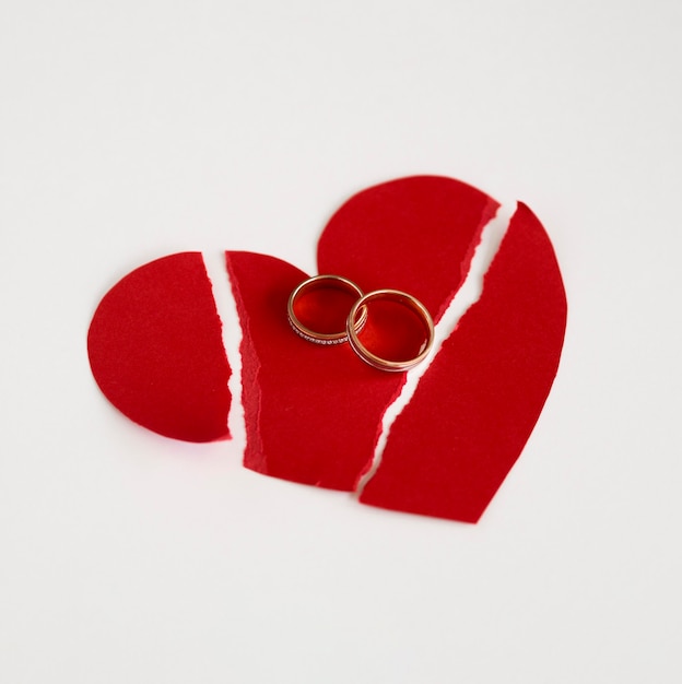 Anillos de matrimonio y corazón de papel roto