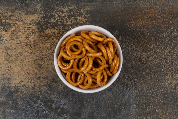 Anillos de pretzel salados en un tazón blanco.