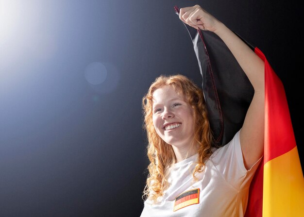 Animando a mujer sosteniendo la bandera alemana con espacio de copia