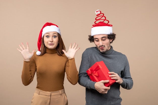 Año nuevo, humor, festivo, concepto, con, divertido, feliz, pareja encantadora, llevando, rojo, santa claus, sombreros, en, gris colección de imágen