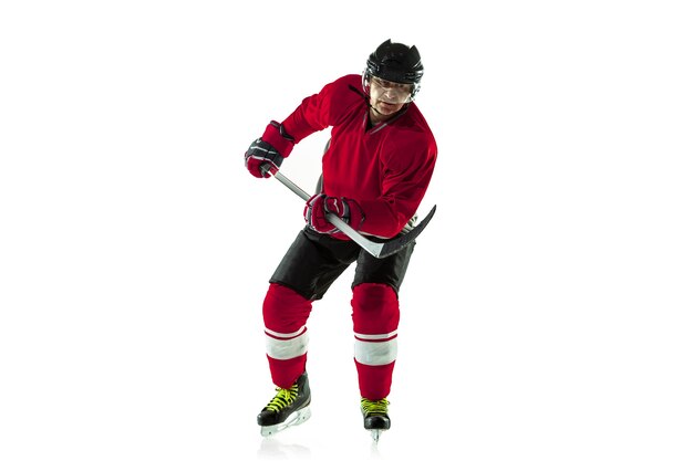 Anotando un gol. Jugador de hockey masculino con el palo en la cancha de hielo y pared blanca. Deportista con equipo y casco practicando. Concepto de deporte, estilo de vida saludable, movimiento, movimiento, acción.