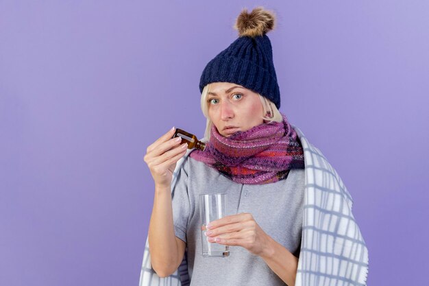 Ansiosa joven rubia enferma mujer eslava con bufanda y gorro de invierno