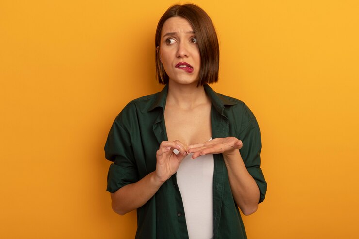 Foto gratuito ansiosa mujer bastante caucásica muerde los labios y mira a un lado en naranja