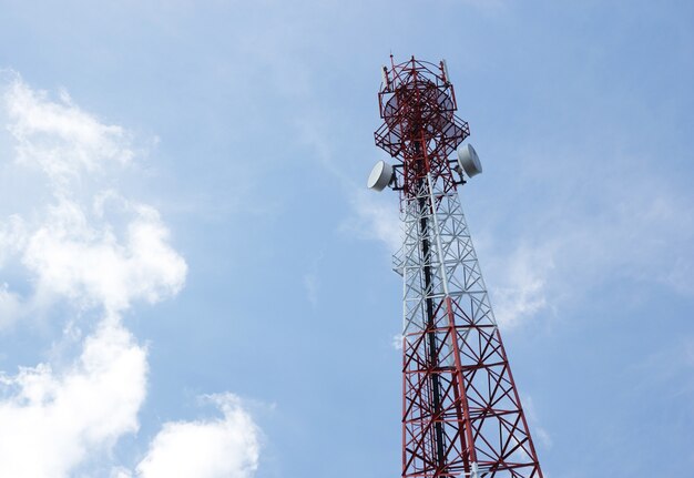 Antena de telecomunicaciones para la radio, televisión y teléfono con nubes y cielo azul