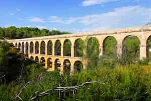 Foto gratuita antiguo acueducto romano en el bosque de verano. tarragona,